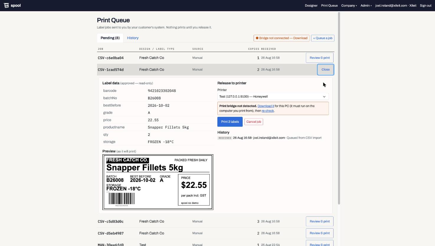 A queued job opened for release: the approved data, a live preview of the finished label, printer selection and job history